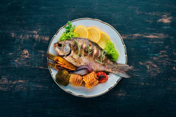 Baked fish carp. On a wooden background. Top view. Copy space.