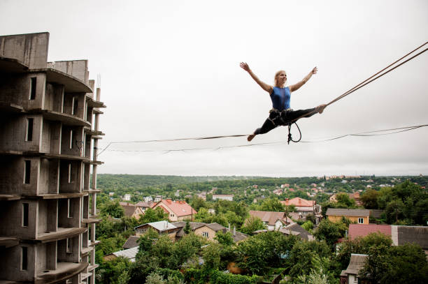 istock Brave smiling young woman balancing on a slackline 1008446744
