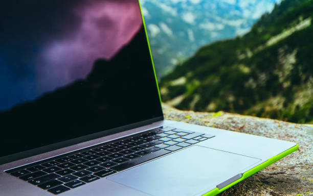 istock Laptop computer at the natural mountain background. Photo depicts notebook computer in the alpine heights. Freelance concept. 1008447054