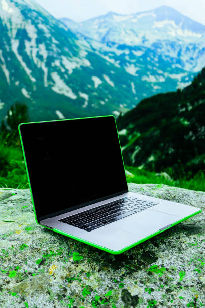 istock Laptop computer at the natural mountain background. Photo depicts notebook computer in the alpine heights. Freelance concept. 1008447090