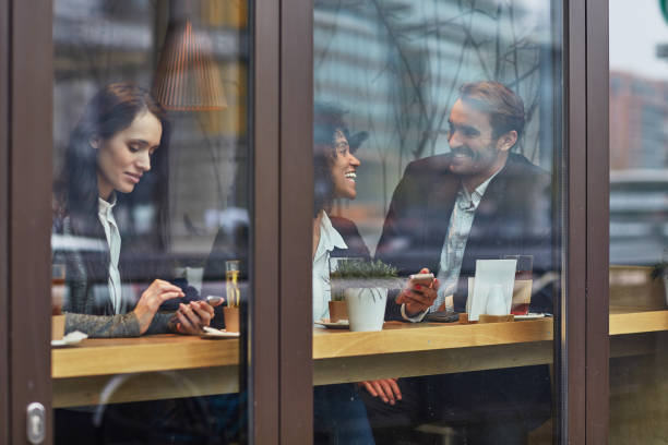 istock Happy coworkers siting at cafe seen through glass 1008457666