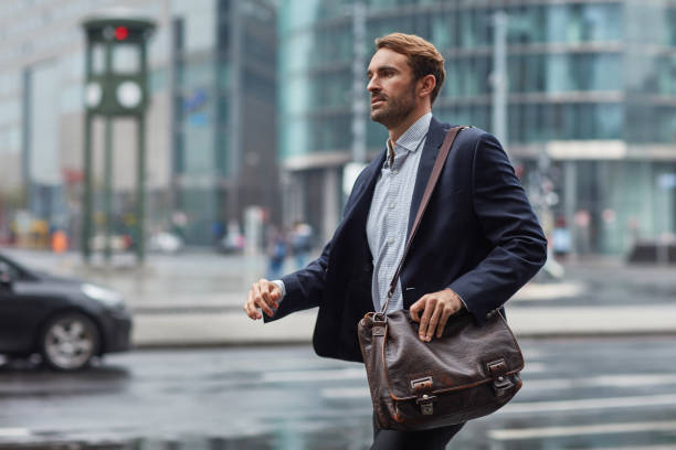 istock Businessman carrying bag while walking by street 1008457832