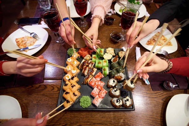 초밥 세트 식당에서 테이블에 롤. 초밥을 먹는 친구의 파티 대나무 지팡이 사용 하 여 롤. - sushi japan restaurant food 뉴스 사진 이미지