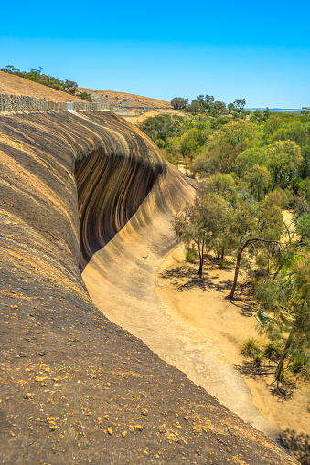 Aerial view from top of famous place of Wave Rock, Australian outback, near Hyden, Western Australia. The natural rock formation is shaped like a tall ocean wave in Hyden Wildlife Park. Vertical shot.
