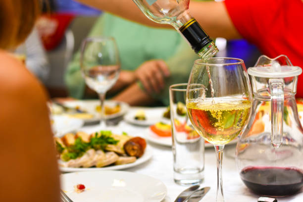 istock White wine is poured into a bottle on a festive table 1008551806