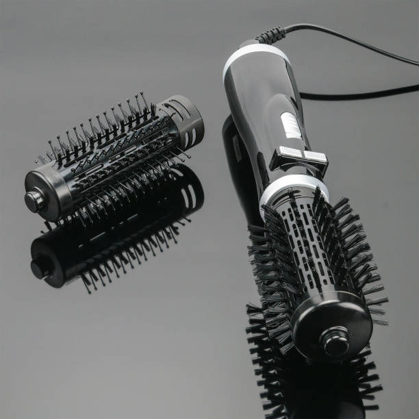 istock Black brush hair dryer on the grey mirror background with accessory 1008560760