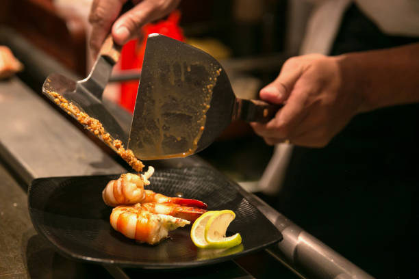 istock Chef pouring sauce into cooked shrimp 1008566134