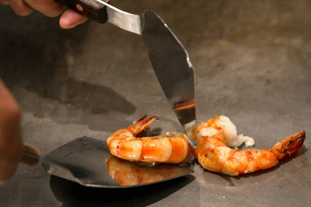 cocinan camarones frescos a la plancha teppanyaki - teppan yaki fotografías e imágenes de stock