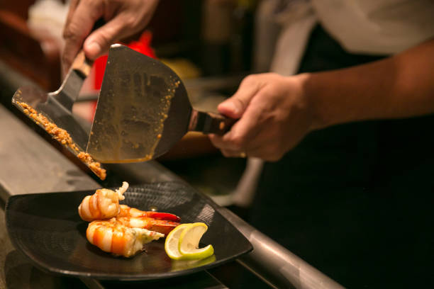 szef kuchni wlewający sos czosnkowy do krewetek - asian cuisine close up garlic vegetable zdjęcia i obrazy z banku zdjęć