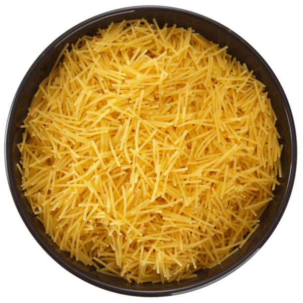 istock Curly pasta in black round clay bowl isolated on white background, top view 1008570424