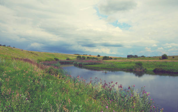 istock Cloudy summer landscape with fields,meadows,woods and small river.Dark stormy clouds in dramatic overcast sky.Rainy season. 1008573246