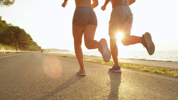 istock SUN FLARE: Unknown jogging couple enjoys the warm summer afternoon sun rays. 1008573286