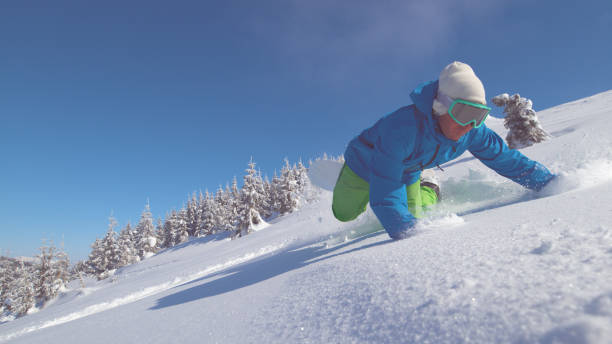 close up: pro snowboardzista na malowniczej zjeżdżywzda w dół góry spada w świeży śnieg - skiing winter sport powder snow athlete zdjęcia i obrazy z banku zdjęć