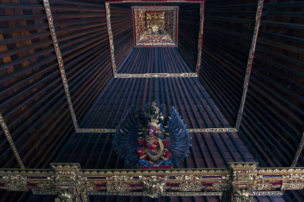 en bois vieux toit de temple à l’intérieur avec la statue de l’esprit - pura goa lawah photos et images de collection