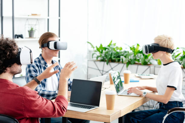 istock young start up team in virtual reality headsets working with laptops in office 1008581770