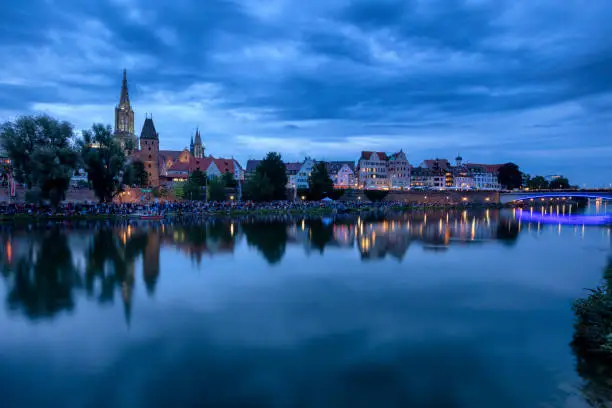 Ulm skyline and crowd of spectators at night during the traditional Light Serenade Festival, view over Danube River