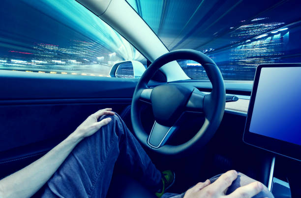 istock Person using car in autopilot mode hands free 1008596060