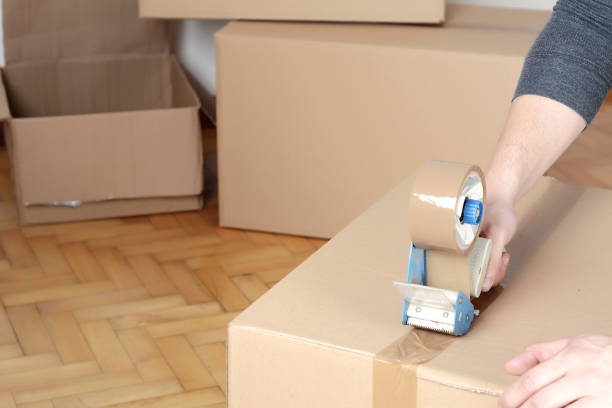 istock Man sealing a shipping cardboard box 1008599494