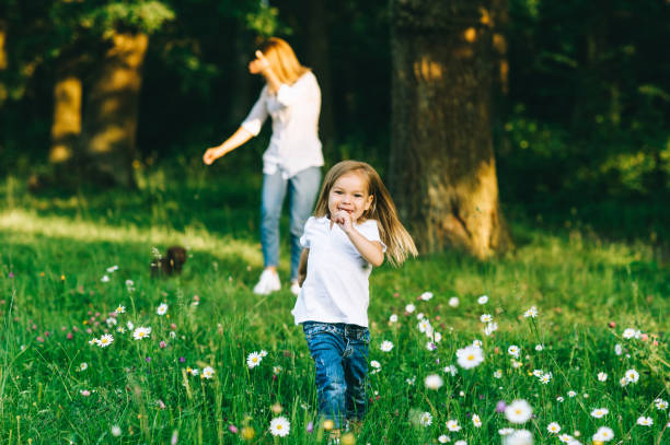 istock selective focus of smiling kid running with mother standing behind in forest 1008600534