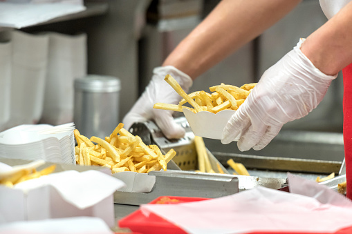 fast food restaurant French fries being prepared by a cook
