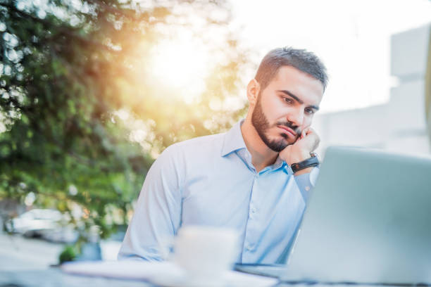 istock Worried man working outdoors in coffee shop. 1008621194