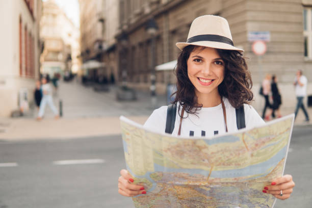 istock Smiling woman with touristic map in her hands 1008636860