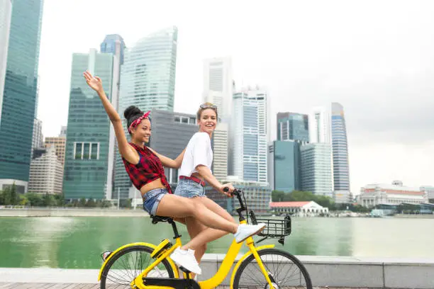Photo of Carefree young women enjoying biking outdoors