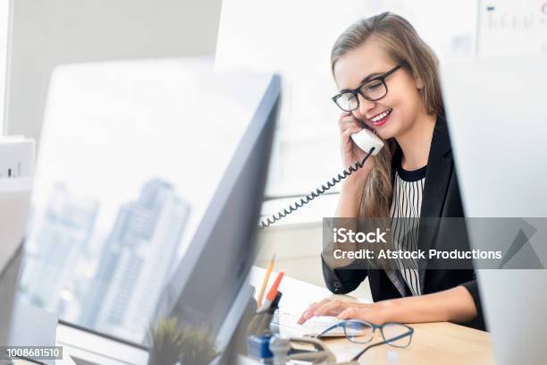 Mujer De Negocios Hablando Por Teléfono Con El Cliente En El Trabajo Foto de stock y más banco de imágenes de Oficina