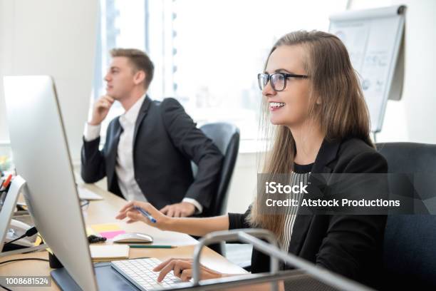 Mujer De Negocios Feliz Trabajando Con La Computadora En La Oficina Foto de stock y más banco de imágenes de Nivel júnior