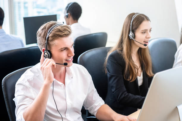 istock Friendly handsome man working in call center office with team 1008681554