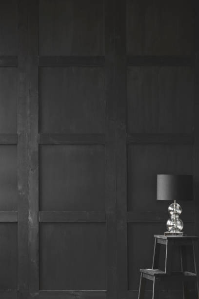 istock Lamp on stool against wooden wall in empty dark black interior with copy space. Real photo 1008688206
