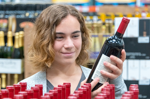 young caucasian woman shopping for wine