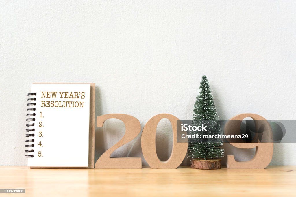 New year's resolution on a notebook and wood number 2019 with christmas tree on wood table and copy space 2018 Stock Photo