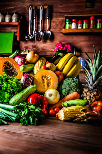 istock Assorted organic tropical fruits and vegetables in a rustic kitchen background. Natural lighting 1008729754