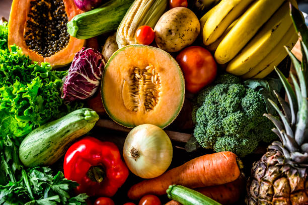 istock Assorted organic tropical fruits and vegetables in a rustic kitchen background. Natural lighting 1008731836