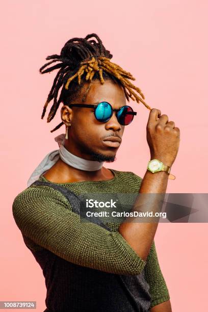 Portrait Of A Young Man In Green With Dreadlocks And Blue Sunglasses Stock Photo - Download Image Now