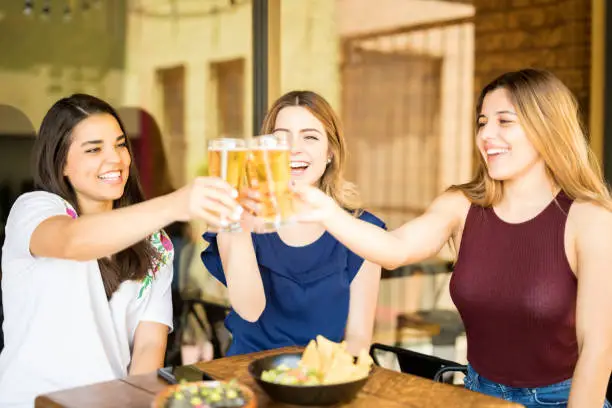 Photo of Girls toasting beers at restaurant