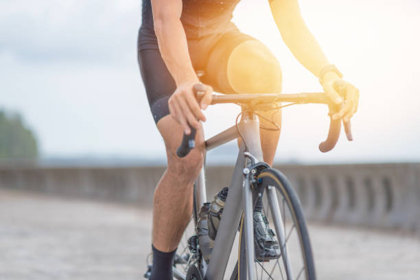 istock Young asian cyclist man ride  bicycle  the beach at the sunset 1008765328