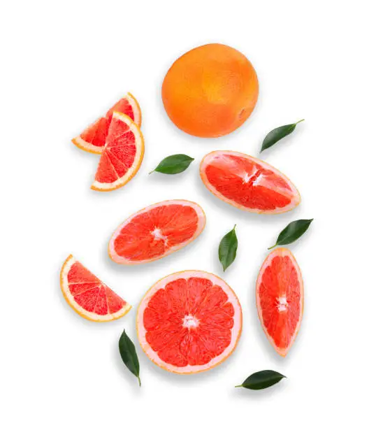 whole and slices grapefruit with green leaves isolated on white background, flat lay, top view