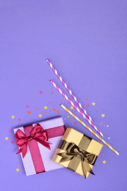 istock Colored shiny classic gift boxes with satin bows and paper striped cocktail straws with confetti 1008786334