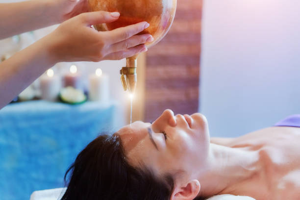 femme bénéficiant d’une huile ayurveda massage soin dans un spa - ayurveda massaging aromatherapy chakra photos et images de collection