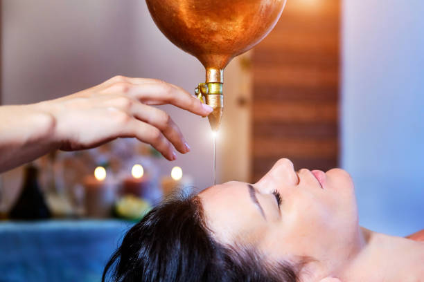 woman enjoying a ayurveda oil massage treatment in a spa - ayurveda massaging aromatherapy chakra imagens e fotografias de stock