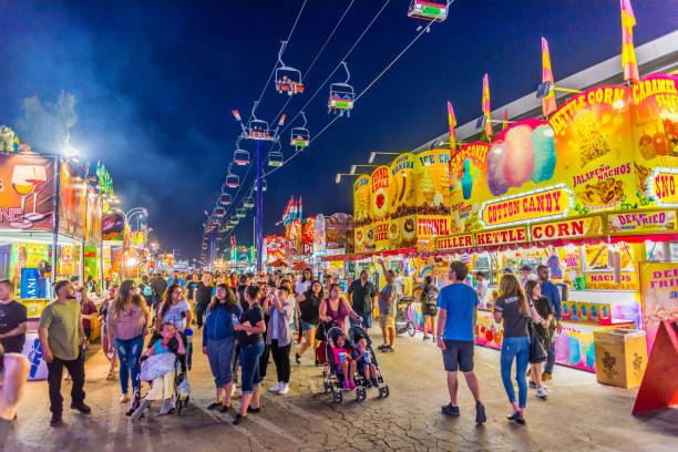 Arizona State Fair People stroll down the main thoroughfare at the Arizona State Fair in Phoenix. midway fair stock pictures, royalty-free photos & images