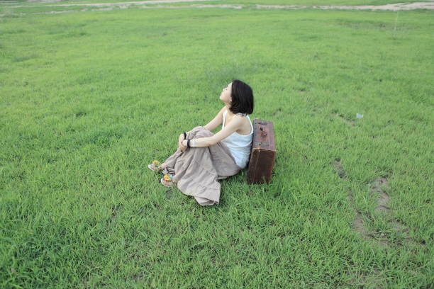 ASian woman sitting on the lawn grass