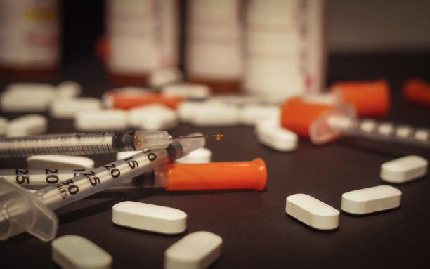 Used Syringe and Opioids An used syringe is discarded while prescription medication is strewn about haphazardly. methadone stock pictures, royalty-free photos & images