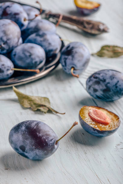 istock Plums with leaves and knife over wooden surface 1008828558