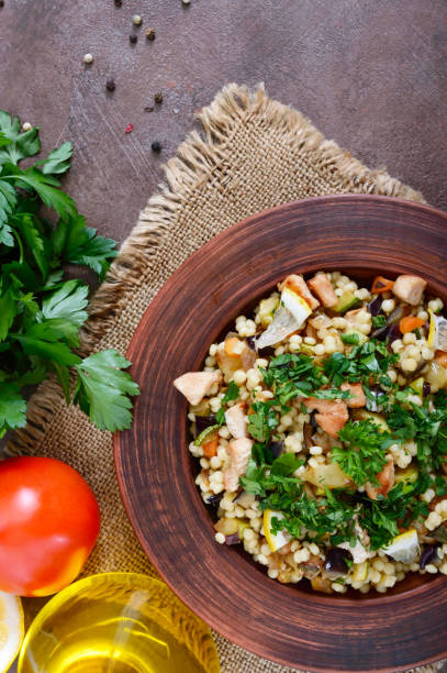 taboulé - salat aus couscous, fleisch, gebratenem gemüse und petersilie in einer schüssel lehm heiß. libanesische küche. die ansicht von oben - tabbouleh vegeterian food middle stock-fotos und bilder