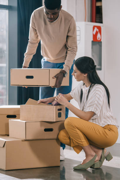 istock young multiethnic coworkers unpacking cardboard boxes during relocation in new office 1008844876