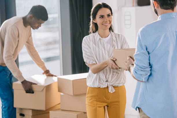 istock multiethnic coworkers carrying cardboard boxes during relocation in new office 1008844912