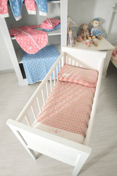 istock Modern baby bedroom in white with bed, bookcase, and carpet 1008847914